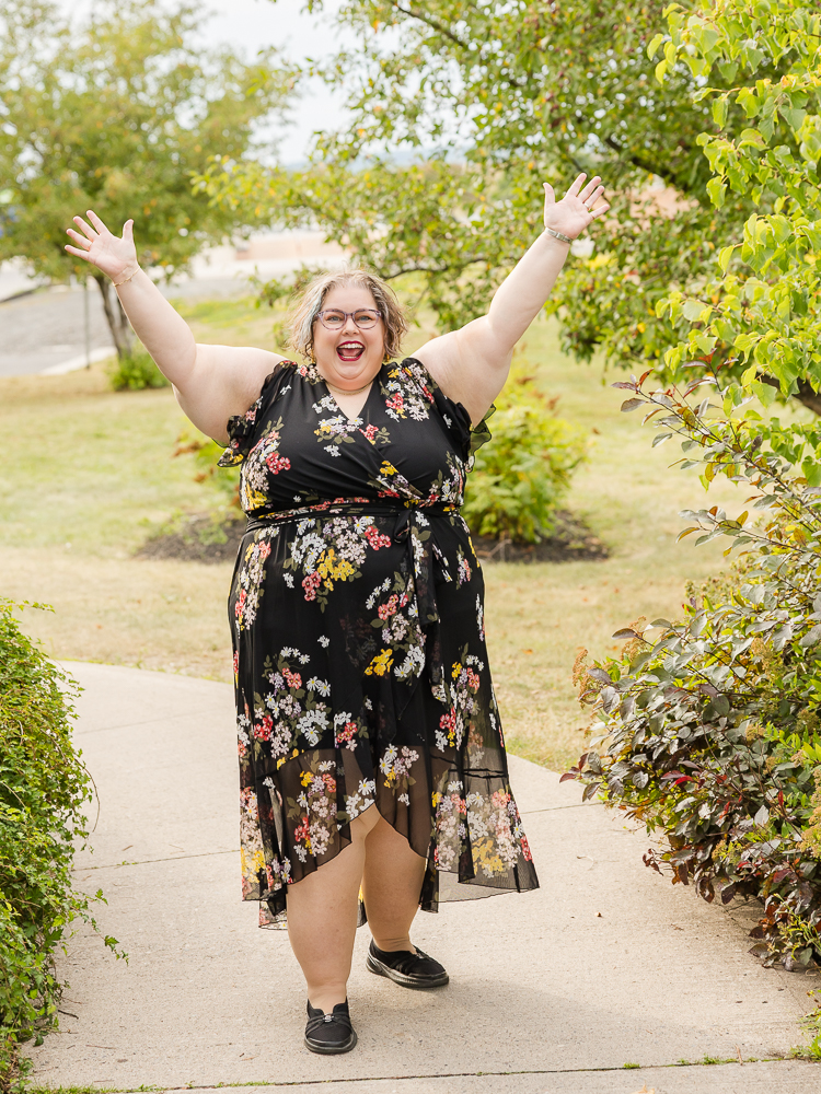 Tish MacWebber smiling with her arms raised outdoors