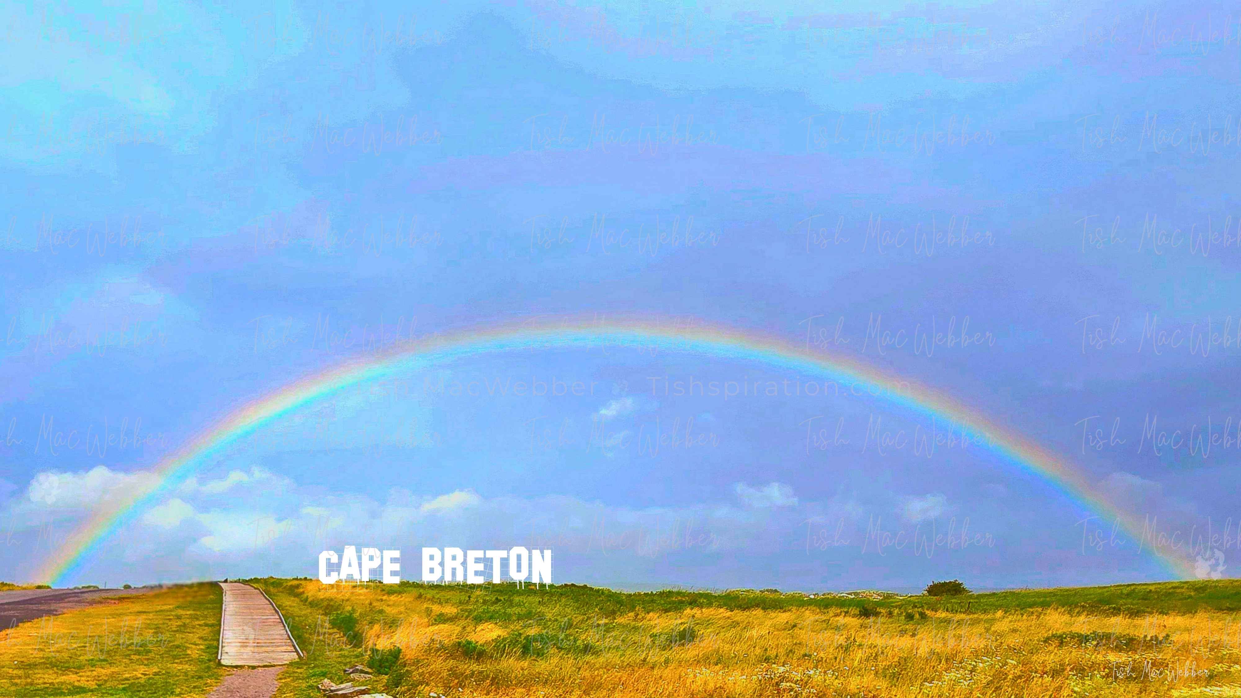 Vivid full rainbow over the Inverness boardwalk and town in Cape Breton, Nova Scotia, with bold CAPE BRETON lettering