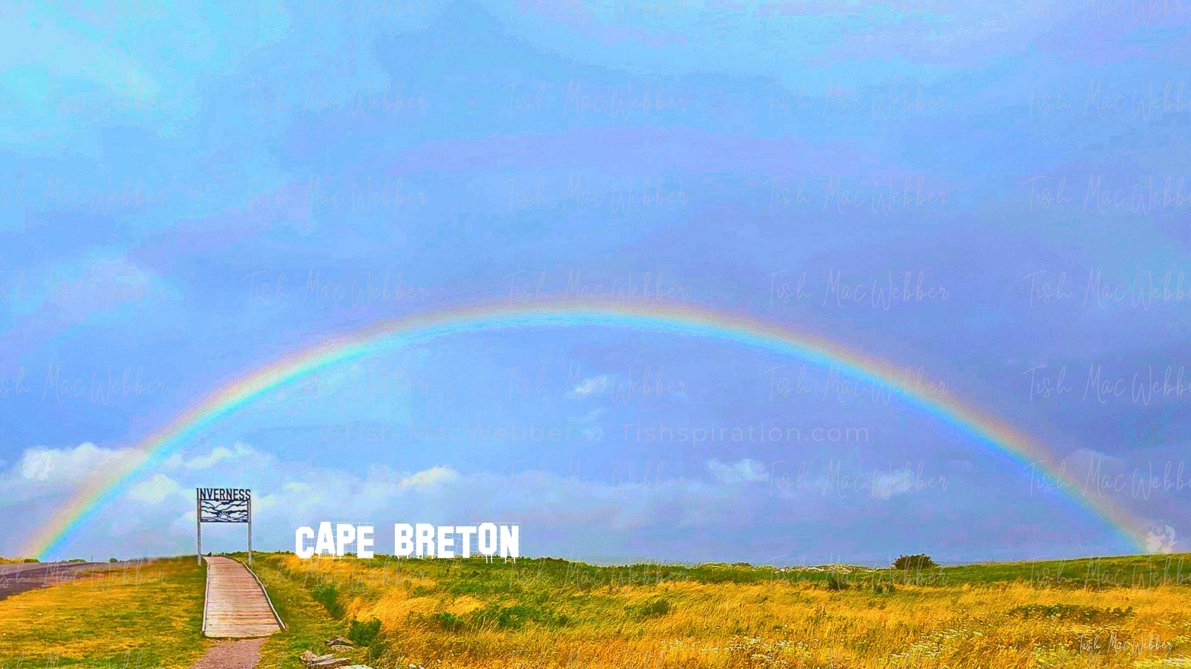 Vivid full rainbow over the Inverness boardwalk and town in Cape Breton, Nova Scotia, with the Inverness sign and bold CAPE BRETON lettering