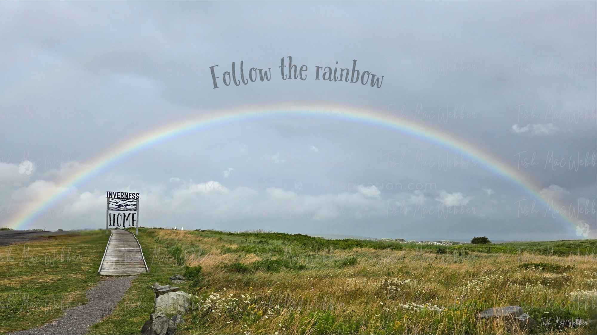 Full rainbow over the Inverness boardwalk and town with the Inverness sign and the words Follow the rainbow and HOME.