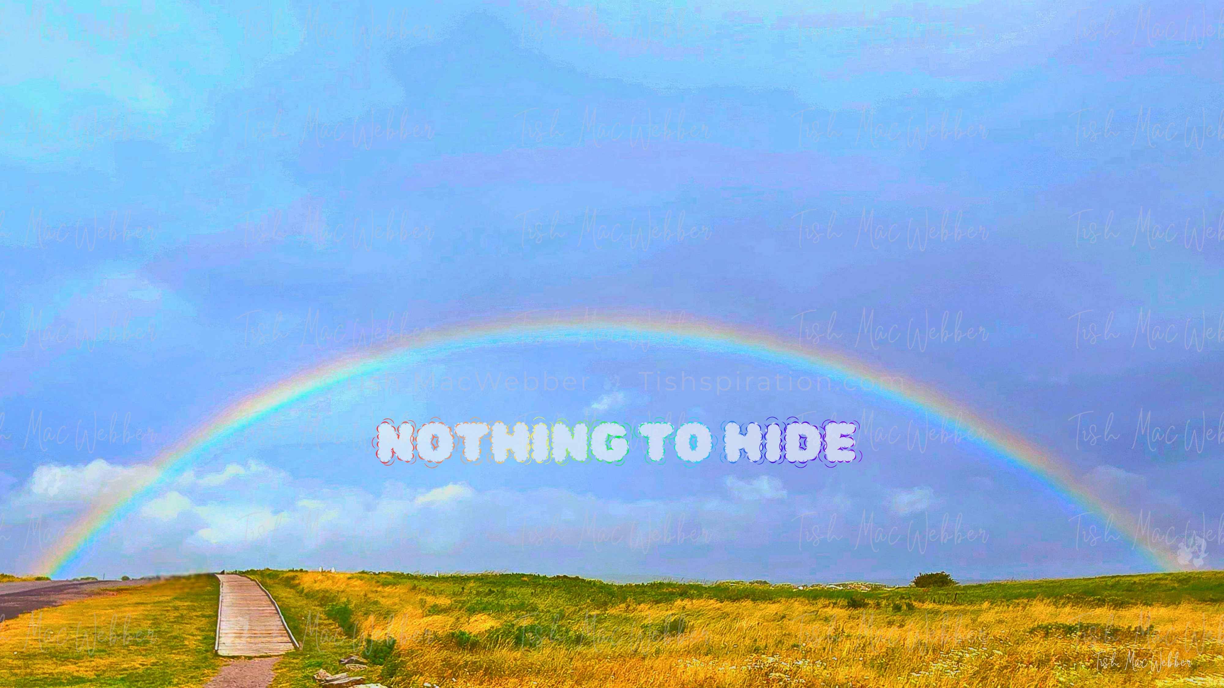 Vivid full rainbow over the Inverness boardwalk and town in Cape Breton, Nova Scotia, with rainbow-coloured NOTHING TO HIDE lettering